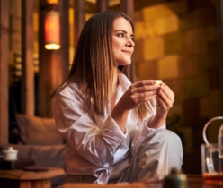Charming young woman drinking tea in cafe