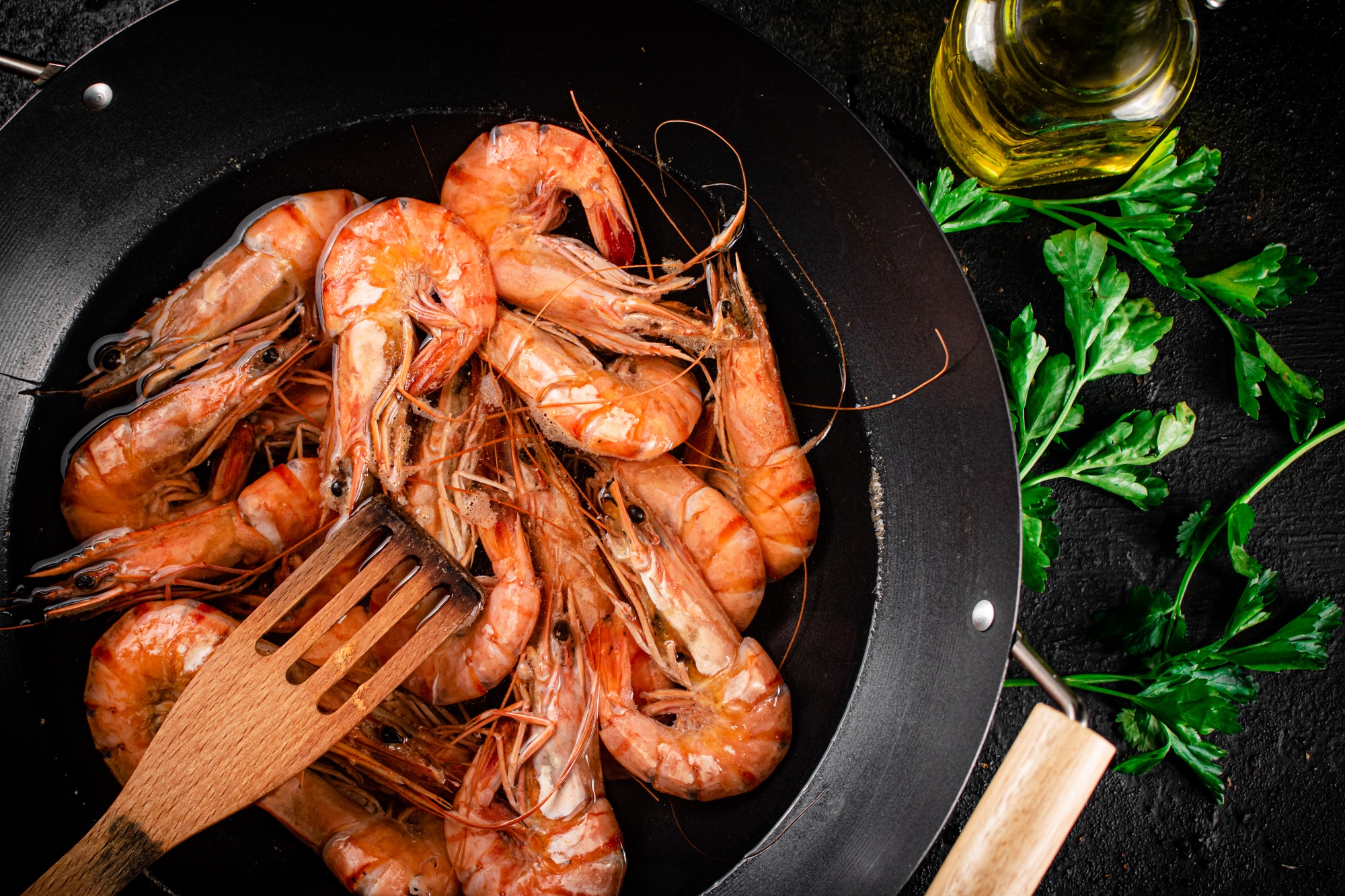 Pot of cooking shrimp with parsley.