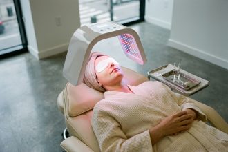 Femme recevant un soin de photothérapie esthétique par LED rouge et bleue dans une clinique moderne